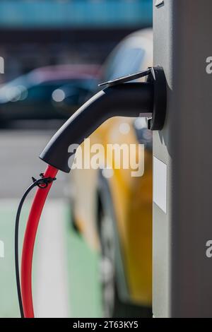 Contemporary public electric vehicle charging station with gun chargers on the street in city Stock Photo