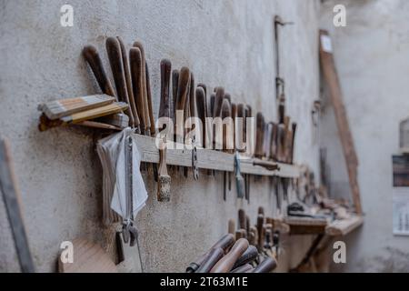 An assortment of well used carpentry tools meticulously organized against a rustic wall in a traditional Toledo workshop Stock Photo