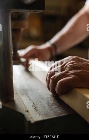 A close-up view of anonymous carpenter hands as he works with wood on machinery in a Toledo workshop Stock Photo