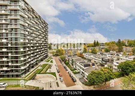 Aerial view of cityscape with modern apartment buildings and parking lot under cloudy sky during sunny day Stock Photo