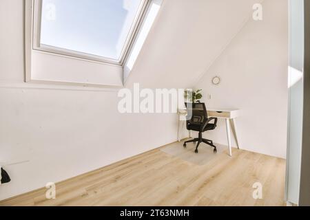 Empty modern workplace with desk and office chair in modern house with bright window and white walls Stock Photo