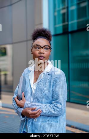 a woman in casual clothes walks around the city, lost among the skyscrapers Stock Photo
