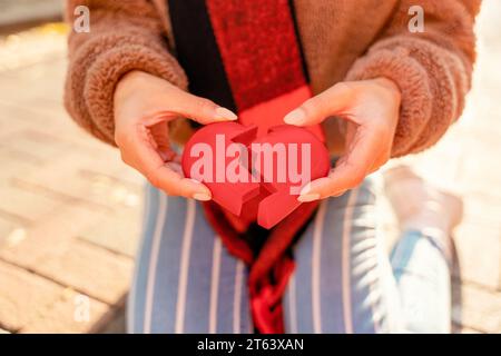 Woman Hands holding a red broken heart.   Getting a divorce concept Stock Photo