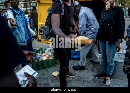 Michael Bunel/Le Pictorium - Exile in the land of human rights - 17/08/2018 - France/Ile-de-France (region)/Paris - Food distribution in the Anais Nin garden by Bassidi from the association -boudoudebougoumoufede-. He is one of the citizens who choose to provide food to refugees and migrants on a daily basis. Around 500 meals are distributed. August 17, 2018. Paris. France. In October 2015, the municipality presented eighteen commitments in a document entitled 'Mobilizing the Paris community to welcome refugees'. The document opens with this sentence: 'Paris, like other refugee ci Stock Photo