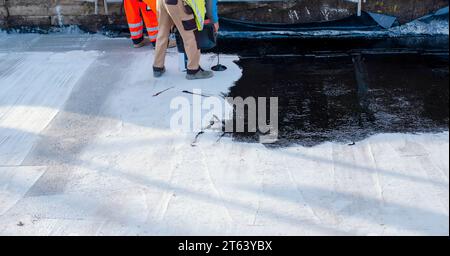 Waterproofing coating. Builder applying waterproofing bitumen mastic on concrete Stock Photo
