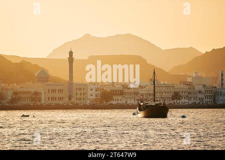 Harbor with traditional wooden boat Dhow and waterfront of old town in Muscat. Sultanate of Oman. Stock Photo
