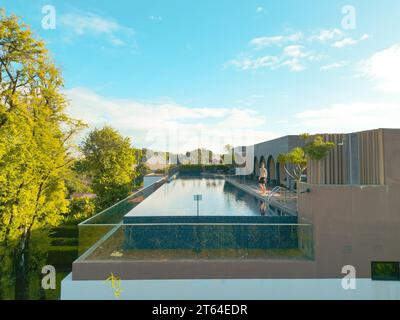 Fit Man Strikes a Pose by the Rooftop Infinity Pool of a Luxury Hotel in Northern Thailand Stock Photo