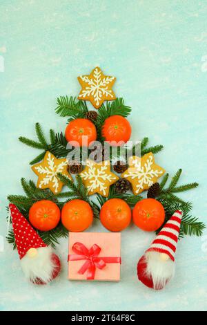Blue winter background with pattern of christmas decorations, tangerines, cones, gingerbread Stock Photo