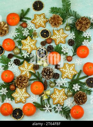 Blue winter background with pattern of christmas decorations, tangerines, cones, gingerbread Stock Photo