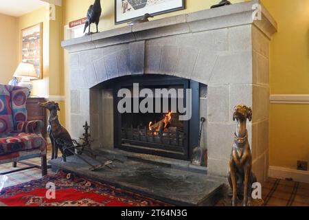 Blazing fire in an old-fashioned granite fireplace - John Gollop Stock Photo