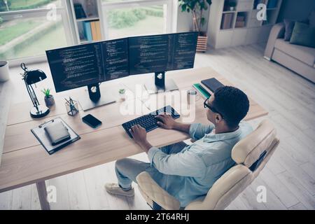 Upper view of young man it specialist create own commercial startup clicks his keyboard computer software development indoors home office Stock Photo