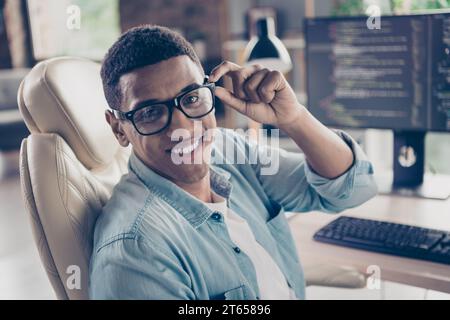 Portrait of attractive intelligent young man working remote using computer professional freelance it specialist at workplace indoors Stock Photo