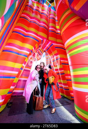 New York, USA, 8th Nov.2023. Argentinian conceptual pop artist Marta Minujín (R) poses for a selfie next to fashion firm Sudestada founder Gimena Garmendia (L) and Times Square alliance artistic director Jean Cooney, inside Minujin's new 'Sculpture of Dreams' installation in Times Square. The vibrant, large-scale, 16-piece inflatable in the artist's signature stripes is Minujín's first public sculpture in New York City in her sixty-year career, and is presented to coincide with the Jewish Museum's major survey exhibition of her work, Marta Minujín: Arte! Arte! Arte!, opening on November 17. C Stock Photo