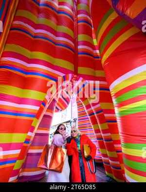 New York, USA. , . Argentinian conceptual pop artist Marta Minujín, 80, poses for a selfie next to fashion firm Sudestada founder Gimena Garmendia, inside Minujin's new 'Sculpture of Dreams' installation in Times Square. The vibrant, large-scale, 16-piece inflatable in the artist's signature stripes is Minujín's first public sculpture in New York City in her sixty-year career, and is presented to coincide with the Jewish Museum's major survey exhibition of her work, Marta Minujín: Arte! Arte! Arte!, opening on November 17. Credit: Enrique Shore/Alamy Live News Stock Photo