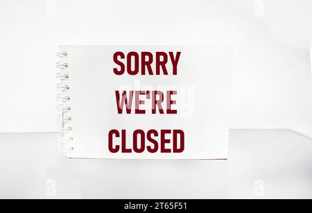Closed business or store concept. Red letters on a notepad. Sorry we are closed on white background Stock Photo