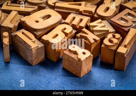 random letterpress wood type printing blocks against handmade textured paper Stock Photo