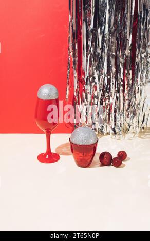 Christmas decoration balls in red glasses with shiny background. New Year's minimal concept. Stock Photo