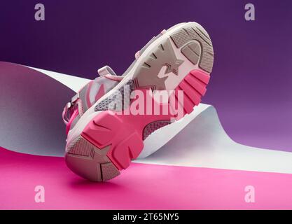 Sport pink-grey-white shoe on multicolor background, sport concept, women's fashion, focus on the sole close up. Stock Photo