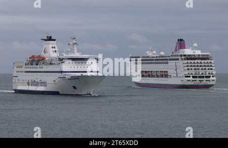 A cruise ship and a ferry pass close to each other in The Solent as they approach the harbour Stock Photo