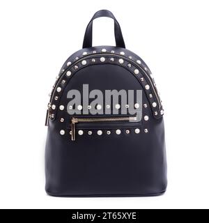Stylish black leather women's backpack with a zipper decorated with gold metal and pearl rivets isolated on a white background. Closeup. Fashion blogg Stock Photo