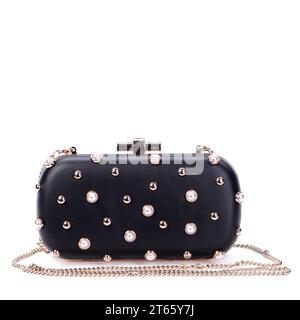 Glamorous black long chain clutch bag for women, decorated with gold metal and pearl rivets isolated on a white background isolated on white backgroun Stock Photo