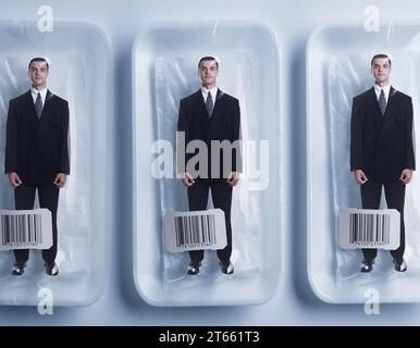 Shrink wrapped packaged businessman clones in a row with UPC codes in studio on white background. Stock Photo