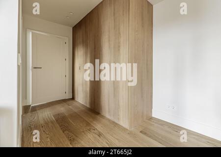 Hallway to a bedroom with fitted wardrobes with custom made light oak doors Stock Photo