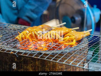 Grilled squid on a charcoal stove at street food. Stock Photo