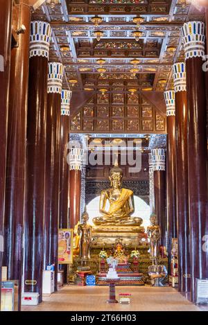 Wat Lok Molee,large,most impressive chedis in Chiang Mai.Tall shiny dark wooden pillars and ornately tiled ceiling.The gold Buddha surrounded by small Stock Photo