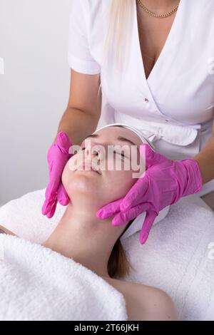 Female Patient Receives Spa Facial Massage Treatment In Spa Salon. Relax And Stress Relief. Professional Skin Care Therapist Takes Care Of Woman. Top Stock Photo