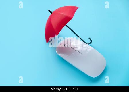 Computer and network security concept. Red umbrella over a computer mouse. Stock Photo