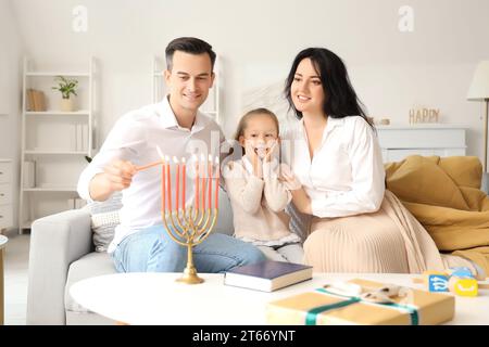 Happy family lighting candles for Hanukkah at home Stock Photo