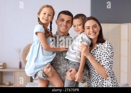 Soldier with his little children and wife at home Stock Photo