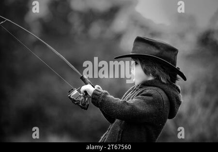 Kid fishing with spinning reel. Kids fly fishing. Stock Photo