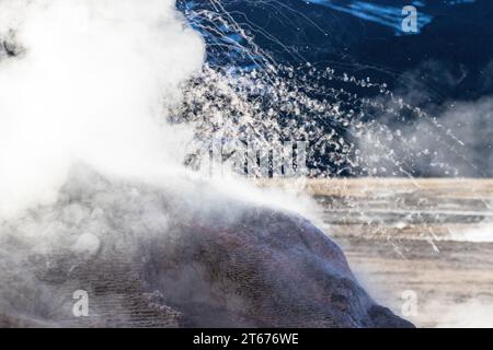 Steam and boiling water spurt out of a geyser cone at the El Tatio geyser field in the early morning in northern Chile. Stock Photo