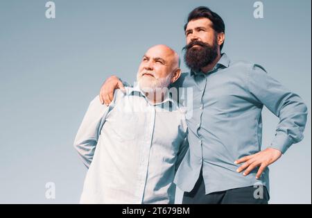 Son hugging his grandfather. Grandfather and son embracing. Grandpa retiree. Male multi generation portrait. Fatherhood. Family generation: future Stock Photo