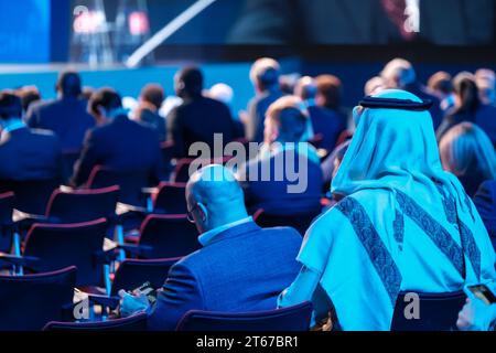 Back view of Arabian businessman attending global conference meeting in illuminated auditorium at export forum Stock Photo