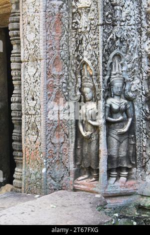 Female Devata figures carved in high relief in a stone column among ruins in the Angkor Archaeological Park. Intricate carvings cover every surface Stock Photo