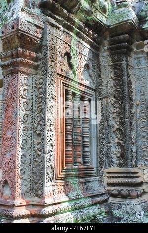 Intricate carvings cover every surface of this stone structure at the Angkor Archaeological Park in Cambodia. The walls still show traces of red ochre Stock Photo