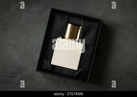 Perfume square bottle mockup in open packaging box on stone table Stock Photo