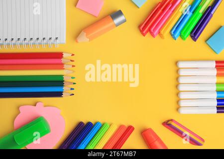 Frame made of different school stationery on yellow background, flat lay and space for text. Back to school Stock Photo