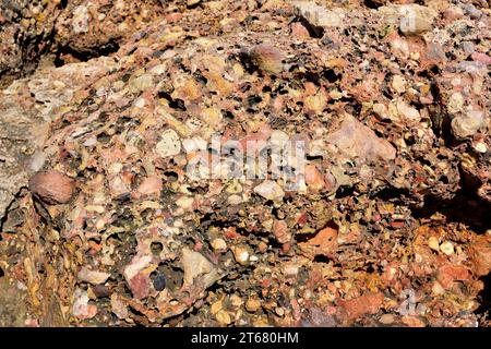 Conglomerate is a clastic sedimentary rock. This photo was taken in L'Ametlla de Mar coast, Tarragona province, Catalonia, Spain. Stock Photo