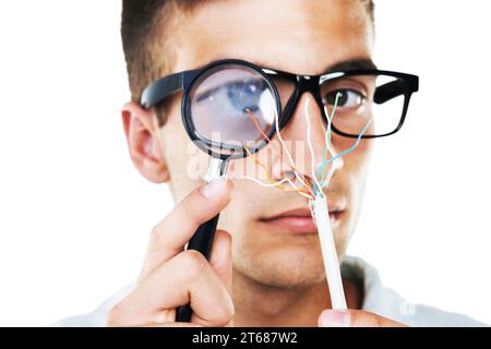 Electrician, cables and portrait of man with test, analysis and check with magnifying glass in white background. Studio, technician or working with Stock Photo