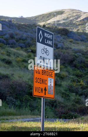 San Francisco, California - April 25, 2023: Low angle view of road signs against scenic mountain during sunny day Stock Photo