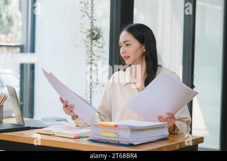 Businesswoman or accounting checking and searching for legal documents to prepare paperwork or reports for tax analysis. Stock Photo