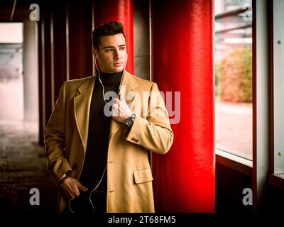 A man in a tan coat and black shirt. Photo of a stylish man in a tan coat and black shirt Stock Photo