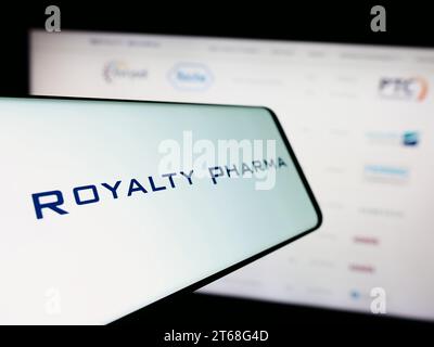 Mobile phone with logo of American biopharmaceutical royalties company Royalty Pharma in front of website. Focus on center-left of phone display. Stock Photo