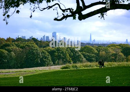 Hampstead Heath, London, England, UK - A couple walking on Prospect Hill near Kenwood House on the heath, with a fine view of the London skyline Stock Photo