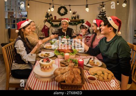 Asian family gathering around the table celebrating Thanksgiving and Christmas with joy and happiness. Stock Photo