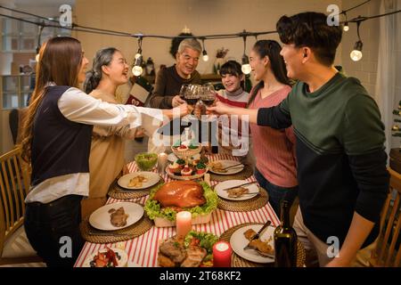 An Asian family celebrating Thanksgiving and Christmas with joy and happiness drinking wine Stock Photo
